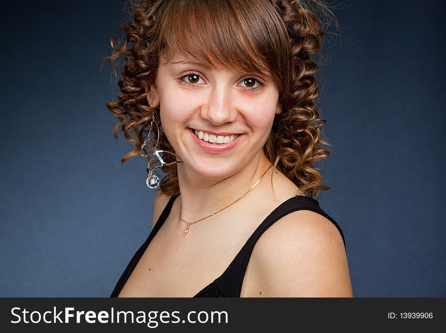 A happy young woman with big smile on dark background