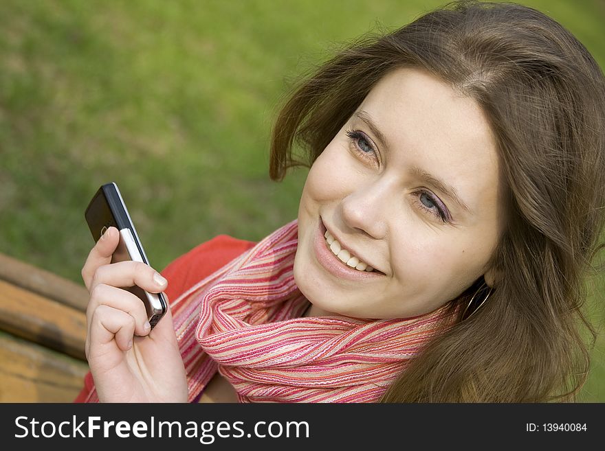 Young beautiful woman read SMS in the park. Young beautiful woman read SMS in the park