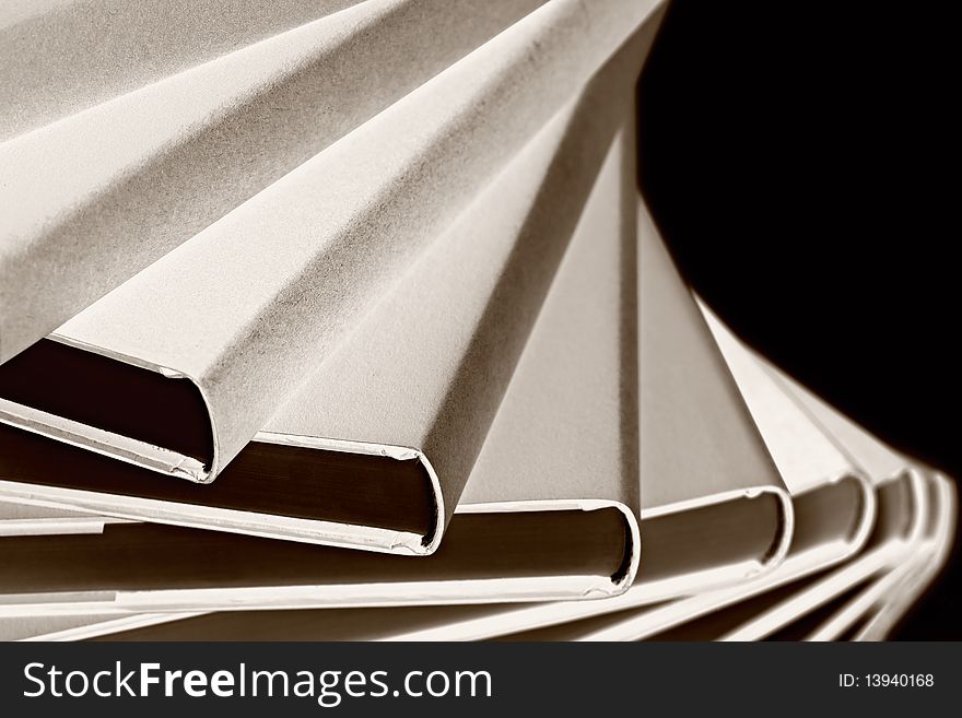 Black & White art conversion: Close-up of winding stack of real books on black background, side view. Black & White art conversion: Close-up of winding stack of real books on black background, side view.