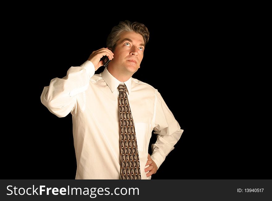 Business man using cell phone on a black isolated background