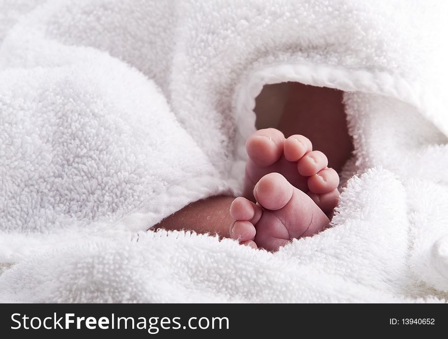 Bare baby feet wrapped in a white towel