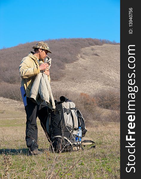 Hiker gets his jacket from the backpack