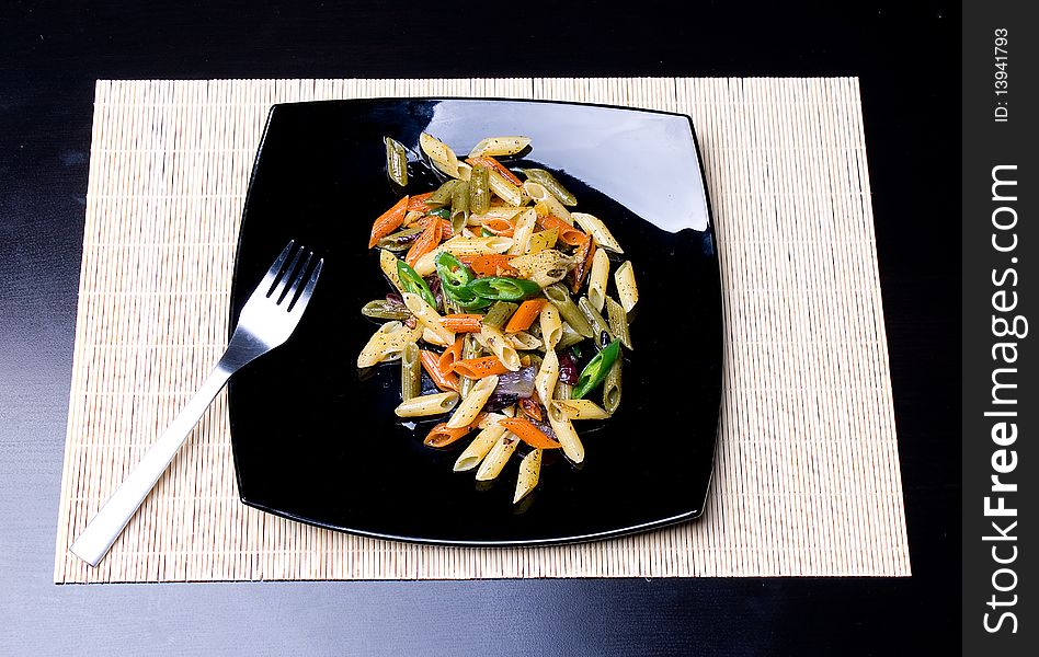 Penne al'oglio with hot green pepper on bladck plate