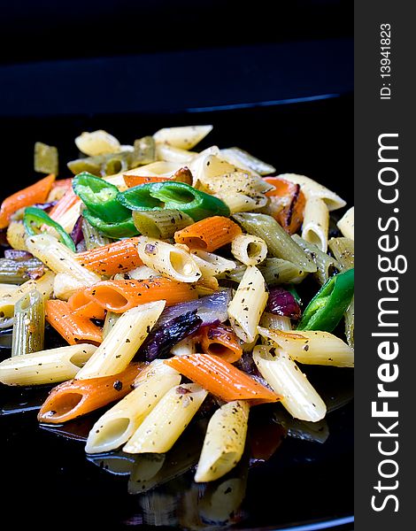 Penne al'oglio with hot green pepper on bladck plate