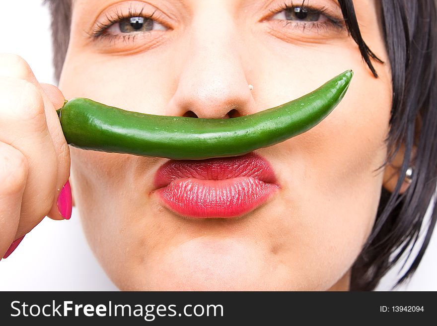 Girl smelling a hot green pepper. Girl smelling a hot green pepper