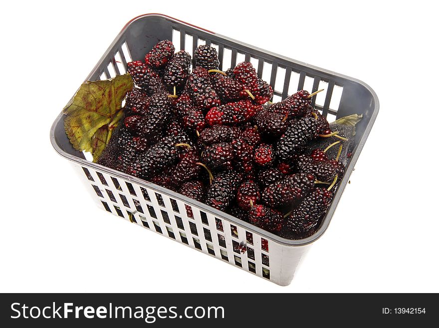 Fresh blackberries in a dark plastic basket.