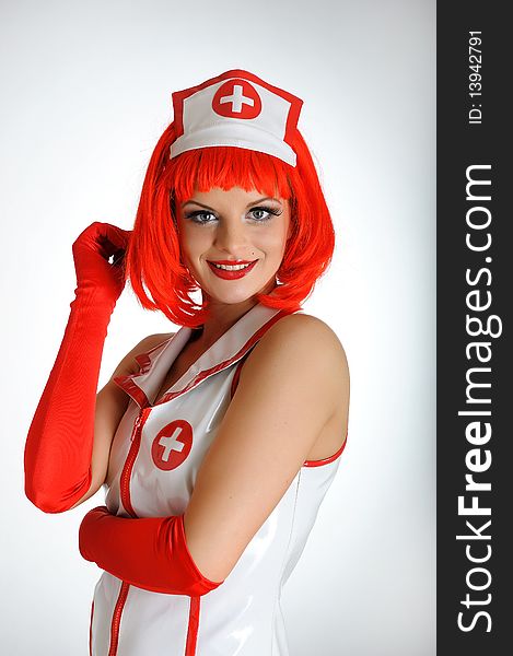 Young sexy nurse with red hair in gloves