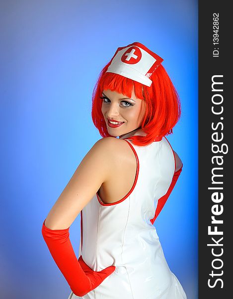 Young nurse with red hair. blue background, copy-space. Young nurse with red hair. blue background, copy-space