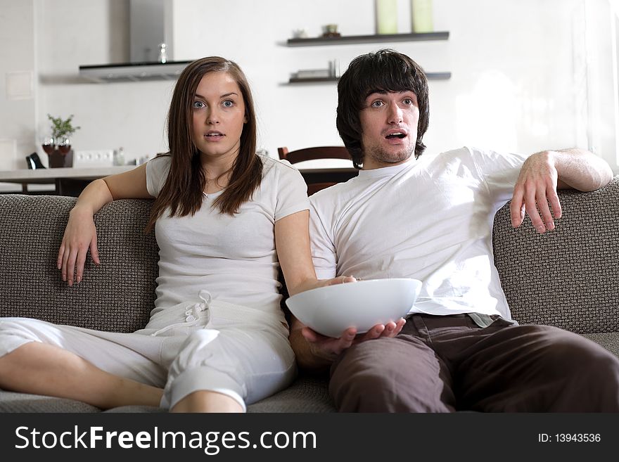 Boy with plate and girl on sofa