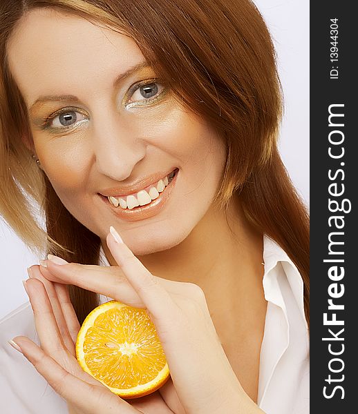 Beautiful cheerful woman with fresh orange near her face