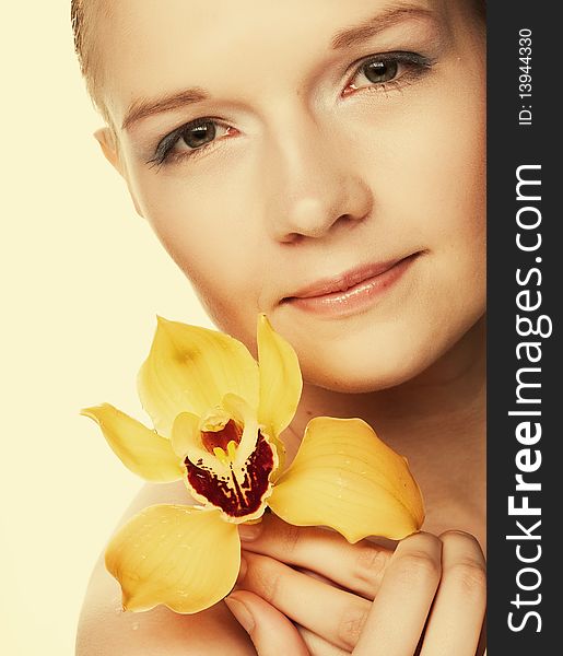 Young woman with yellow orchid