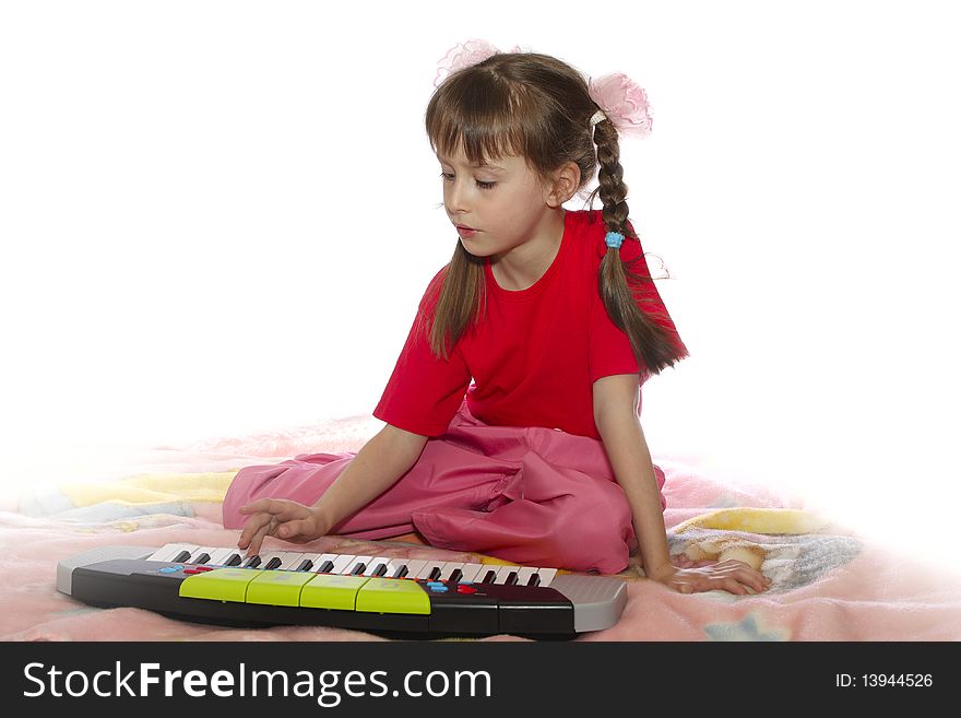 The girl plays a children's musical instrument. The girl plays a children's musical instrument