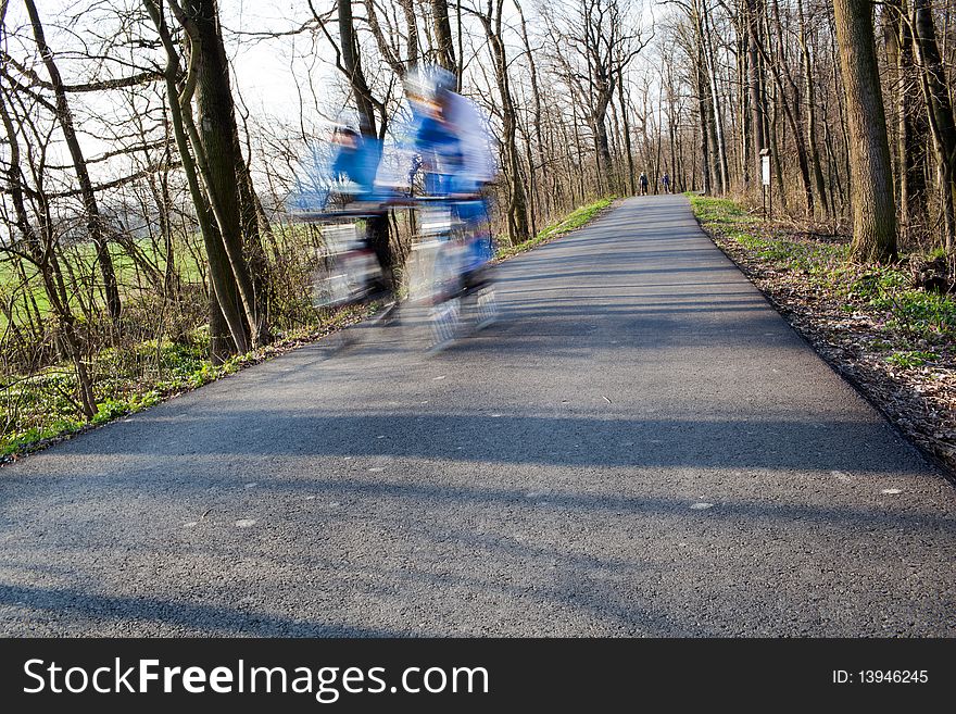 Bikers on a biking path in a park (motion blur is used to convey movement)