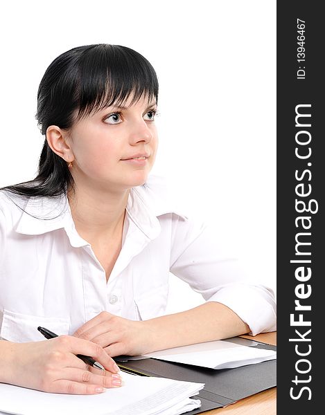 Beautiful young woman in a white shirt sits at a table with the handle in a hand. Beautiful young woman in a white shirt sits at a table with the handle in a hand