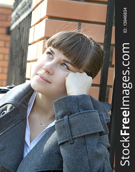 Girl Thinking Near Brick Fence