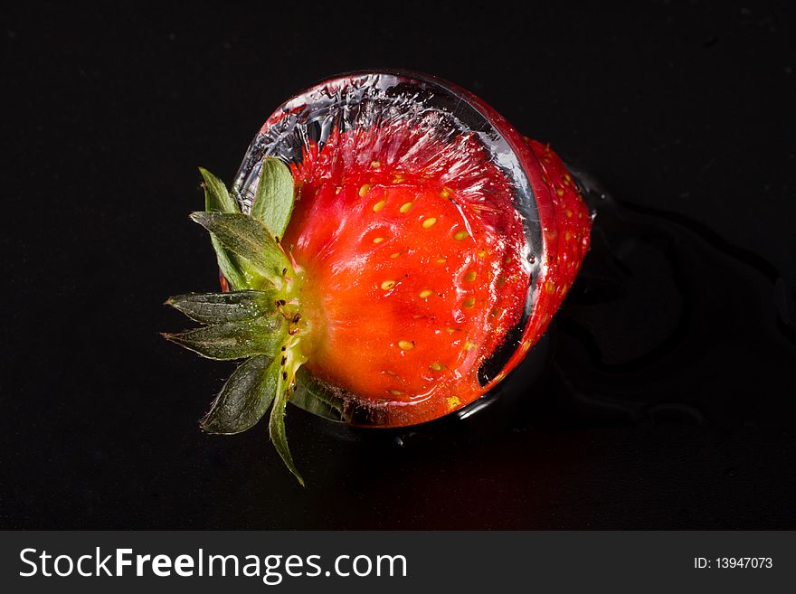 Strawberry in ice on black background