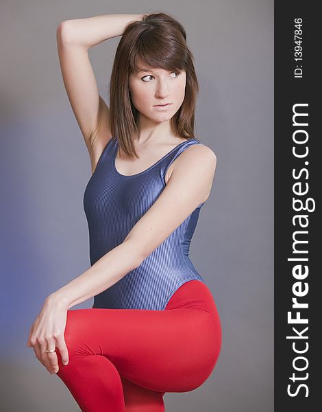 Young female in leotard and leggings doing fitness exercises. Young female in leotard and leggings doing fitness exercises