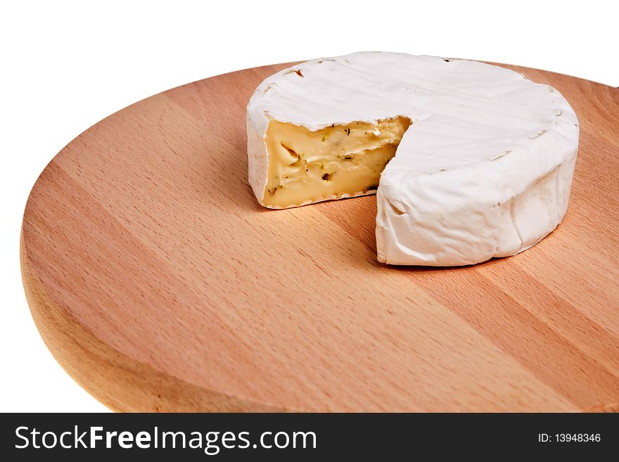 Round camembert block with cut out segment on wooden board over white background. Round camembert block with cut out segment on wooden board over white background.