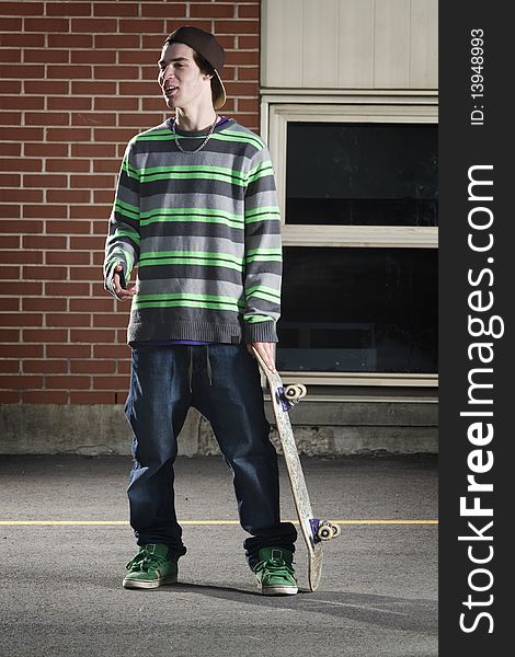 Skateboarder Standing With His Board