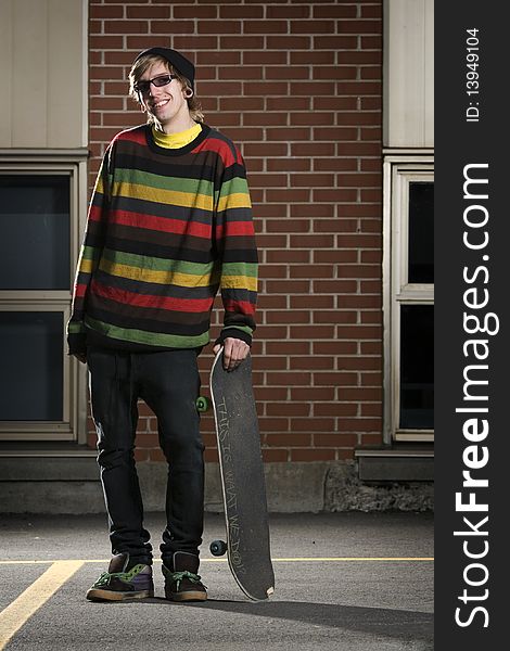 Young Skateboarder Standing Holding His Board