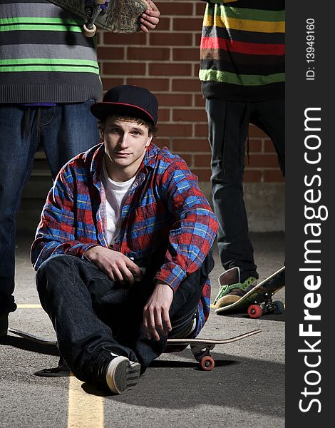 Skateboarder Sitting On His Board