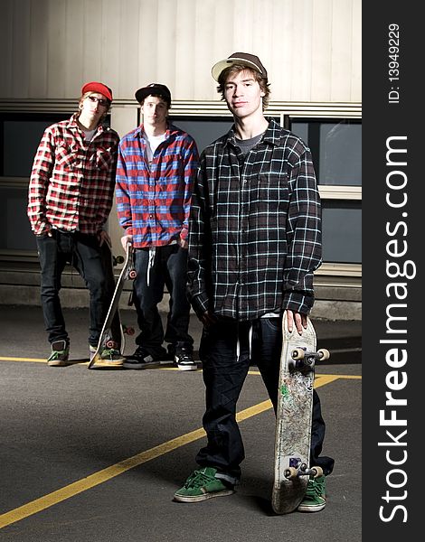 Three Skateboarder Kids Standing In Parking Lot