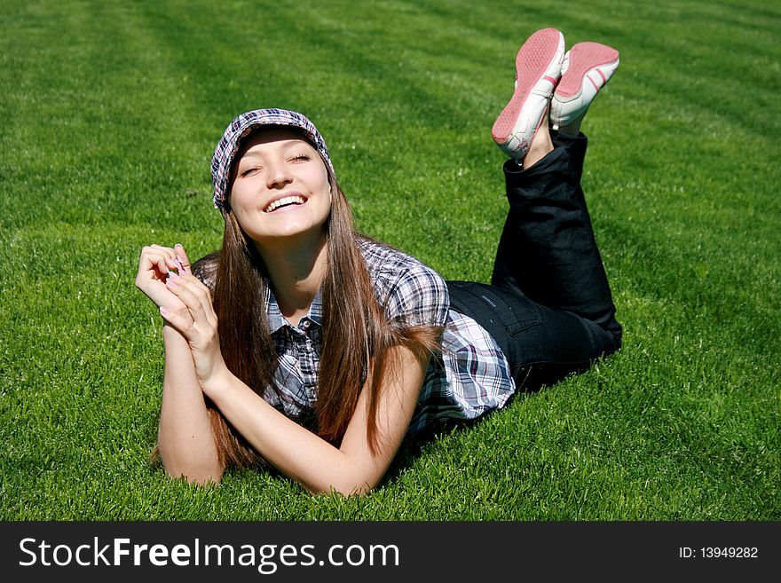 Young caucasian girl sitting on the green grass. Young caucasian girl sitting on the green grass