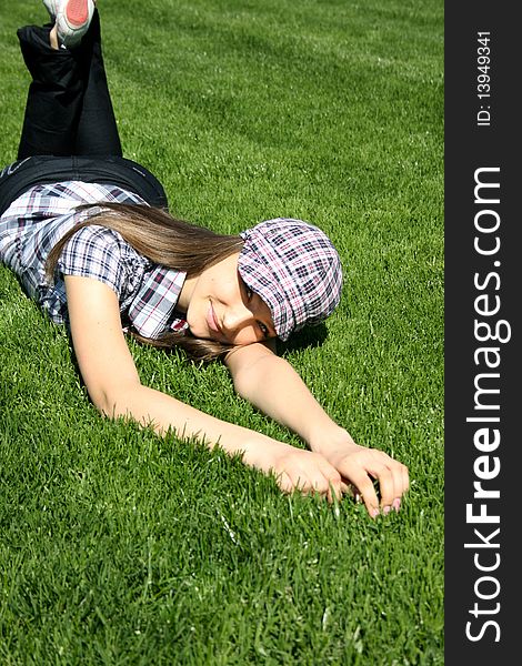 Young caucasian girl relaxing on the green grass. Young caucasian girl relaxing on the green grass