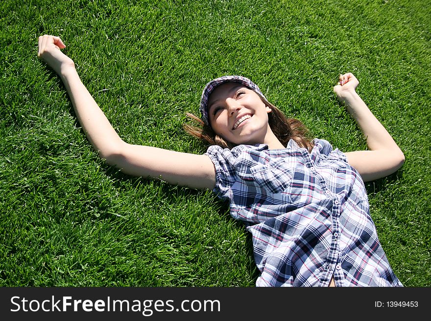 Young caucasian girl relaxing on the green grass