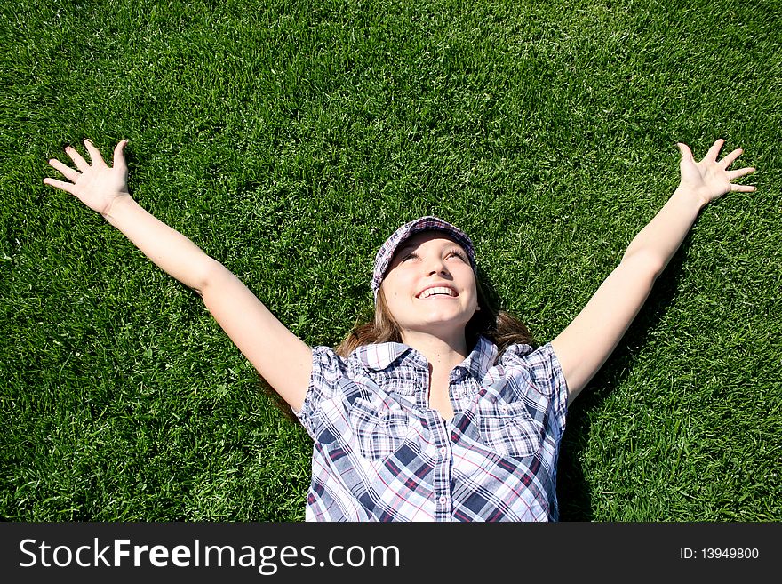 Young caucasian girl laying on the green grass. Young caucasian girl laying on the green grass
