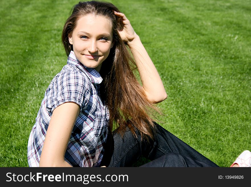 Pretty girl sitting on the green grass