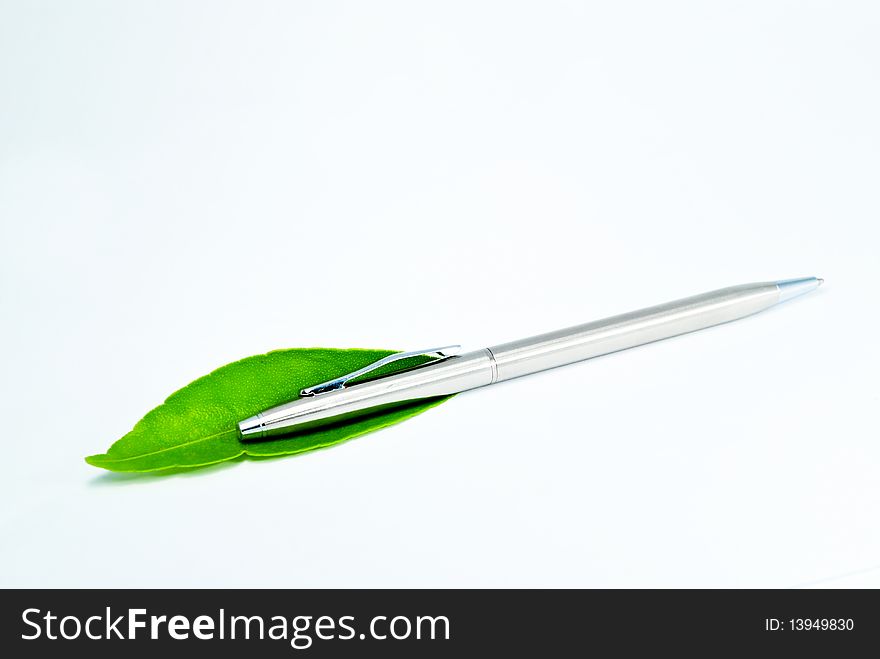 Silver Pen and green leaf in white background. Silver Pen and green leaf in white background.