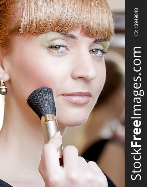 Young woman with a make-up brush