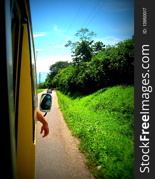 Arm hanging out of bus window with pretty background. Arm hanging out of bus window with pretty background