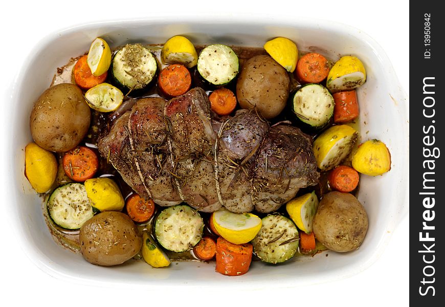 A lamb roast with vegetables in a baking tray