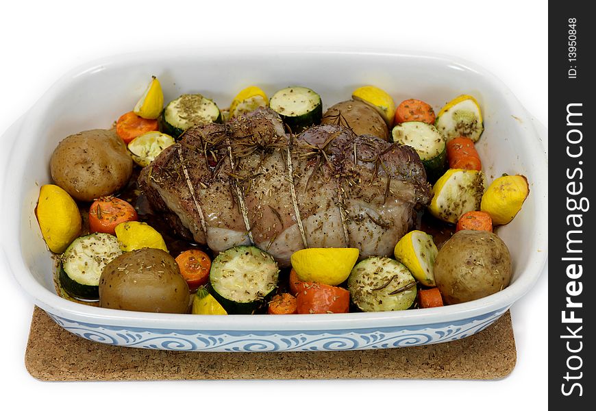 A lamb roast with vegetables in a baking tray