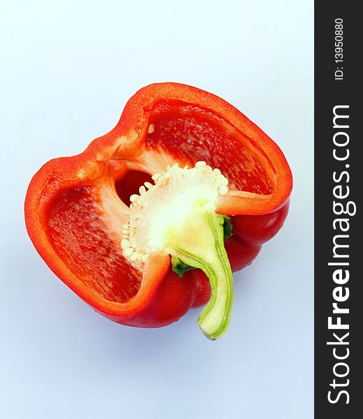 A red capsicum isolated against a blue background