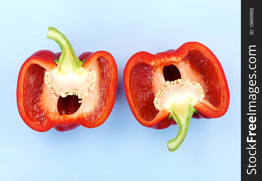 A red capsicum isolated against a blue background