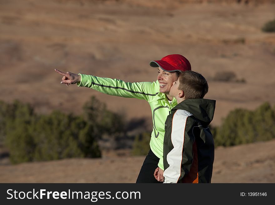Boy kisses his mother on the cheek while stopping on a hike. Boy kisses his mother on the cheek while stopping on a hike.