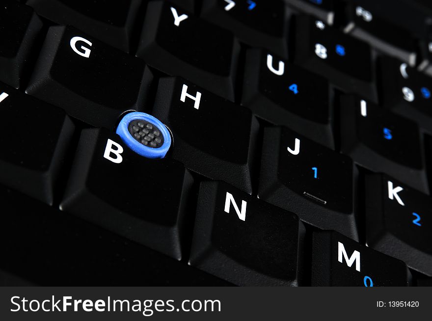 Black keyboard of notebook, with white and blue mark and blue point.