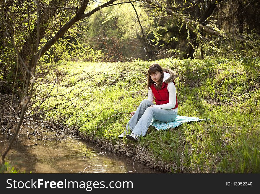 Girl sitting and resting near a river. Girl sitting and resting near a river