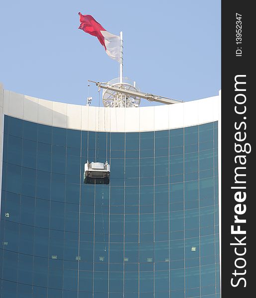 Cleaning of glasses in highrise building with the help of bucket hanged from the top. Cleaning of glasses in highrise building with the help of bucket hanged from the top