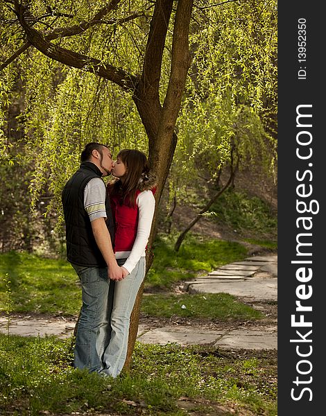 Teenager kissing his girlfriend in the middle of nature. Teenager kissing his girlfriend in the middle of nature