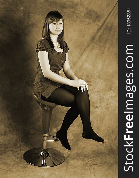 Young woman sitting on a chair and looking at camera. Young woman sitting on a chair and looking at camera