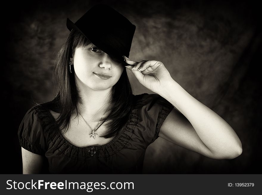 Lady holding her hat and looking at camera. Lady holding her hat and looking at camera