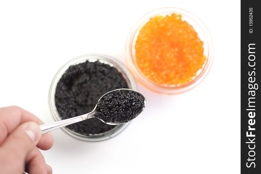 Human hand holding a spoon with black caviar. Human hand holding a spoon with black caviar