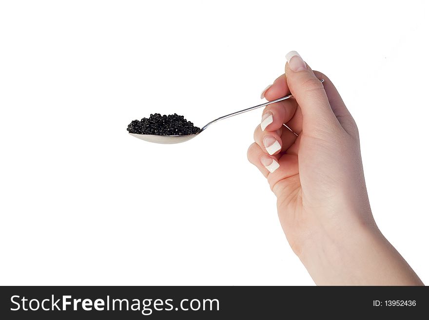 Human hand holding a spoon with black caviar