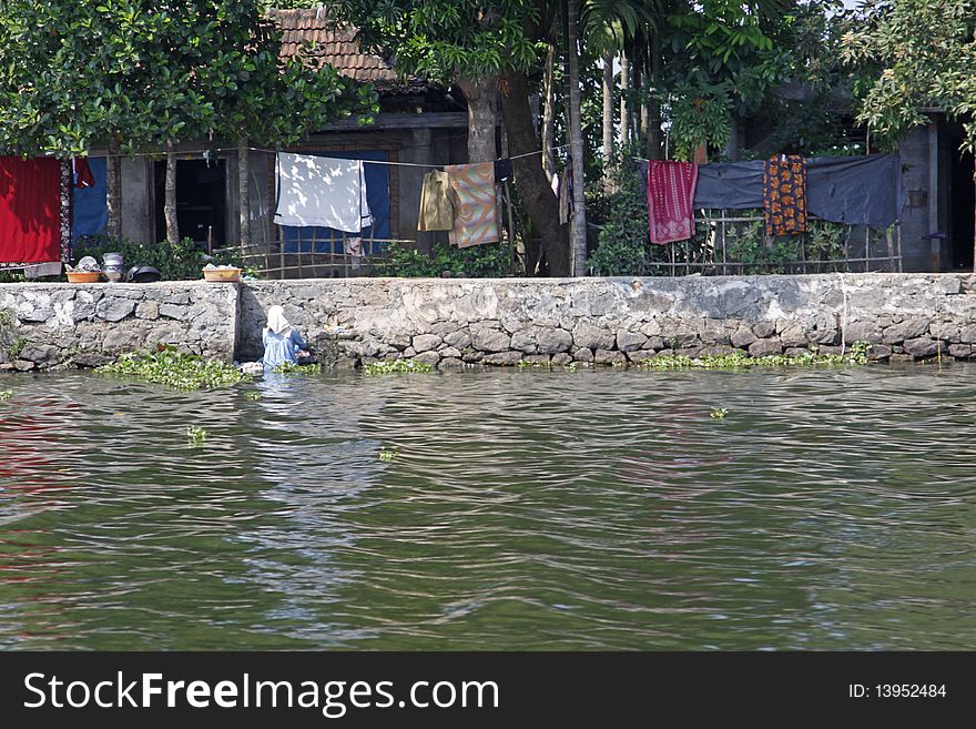 A local woman doing her laundry in the Keralan backwaters, India. A local woman doing her laundry in the Keralan backwaters, India