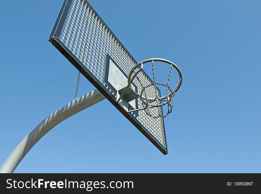 Metal basketball hoop in ghetto with blue sky