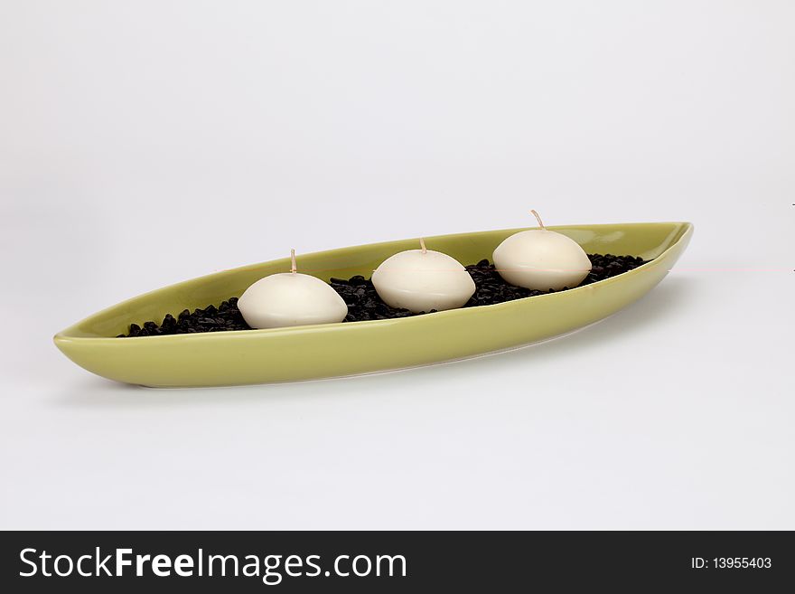Candle boat with three candles and black pebbles in it. Candle boat with three candles and black pebbles in it.
